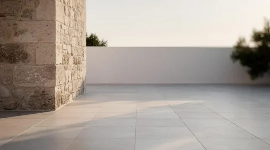 Fachada de piedra y suelo de gres porcelanico envejecidos con elegancia tras decadas de uso, simbolizando durabilidad de 30 anos