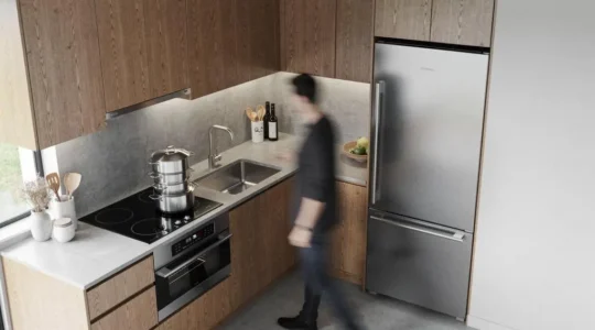 Cocina moderna y luminosa mostrando la disposición eficiente entre la zona de cocción, el fregadero y el frigorífico