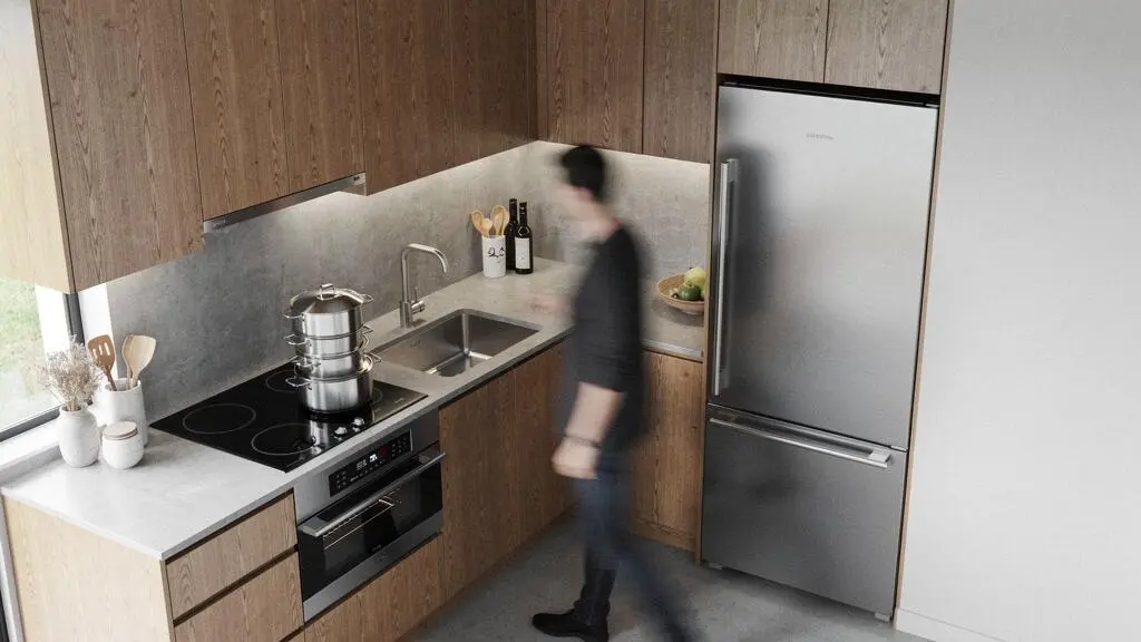 Cocina moderna y luminosa mostrando la disposición eficiente entre la zona de cocción, el fregadero y el frigorífico